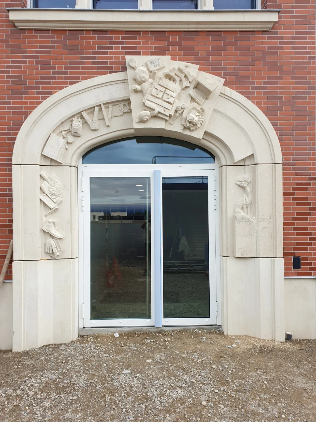 Entrée vitrée sur façade en pierre sculptée