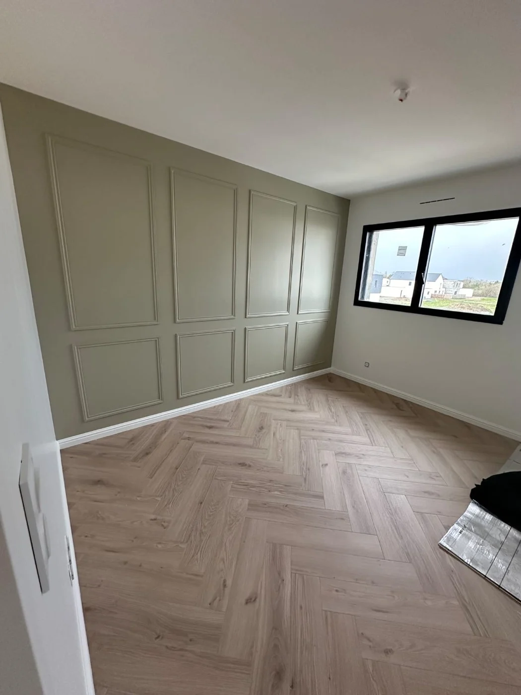 Murs vert sauge à moulures et parquet